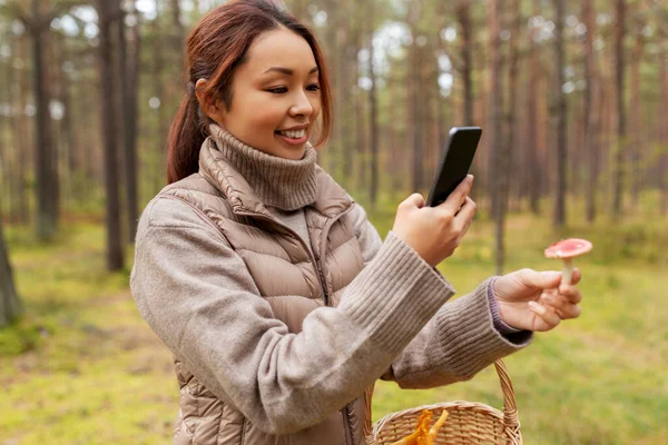 亚洲女人用智能手机辨别蘑菇 — 图库照片