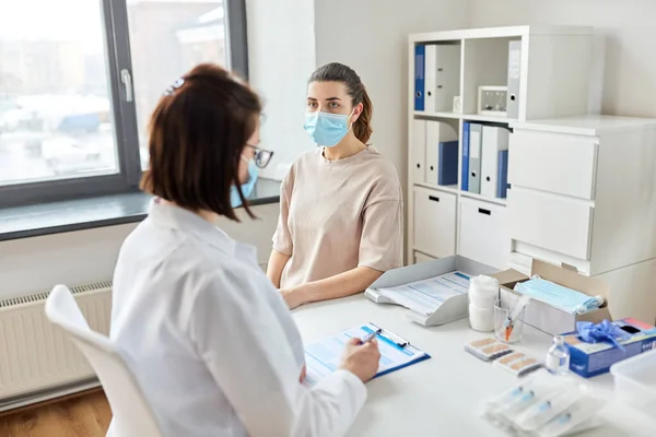 Médecin avec presse-papiers et patient à l'hôpital — Photo