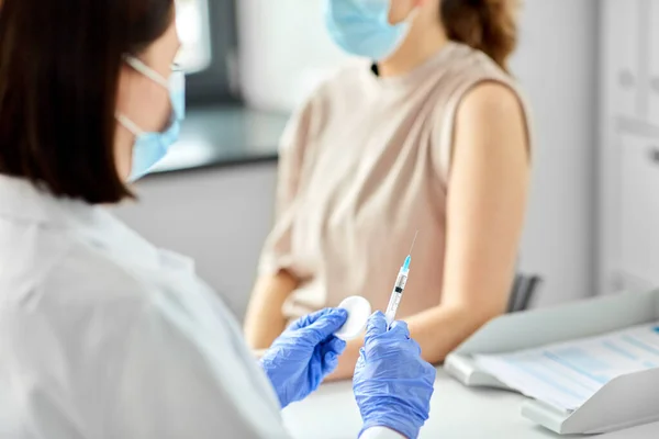 Vrouwelijke arts met injectiespuit vaccinerende patiënt — Stockfoto