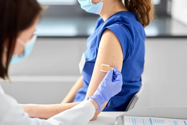 Doctor adjuntando parche al trabajador médico — Foto de Stock