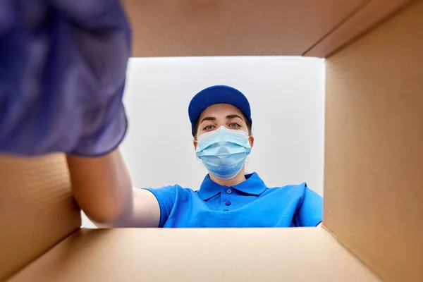 Mujer en máscara mirando dentro de la caja del paquete de cartón —  Fotos de Stock