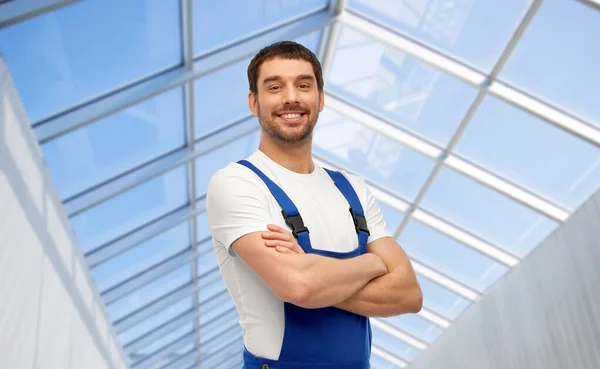 Glücklich lächelnde männliche Arbeiter oder Bauarbeiter im Glashaus — Stockfoto