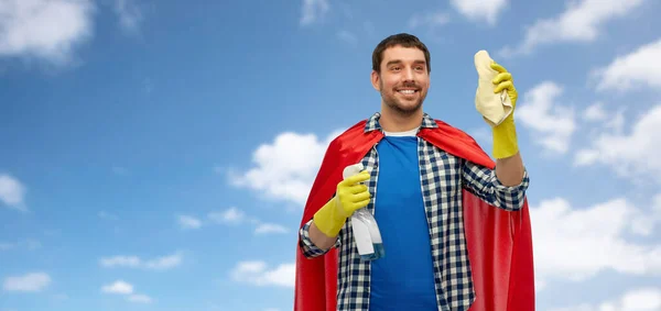 Homem sorridente em capa de super-herói com pano e limpador — Fotografia de Stock