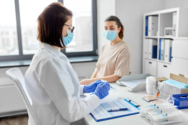 Femme médecin avec seringue et patiente à l'hôpital — Photo