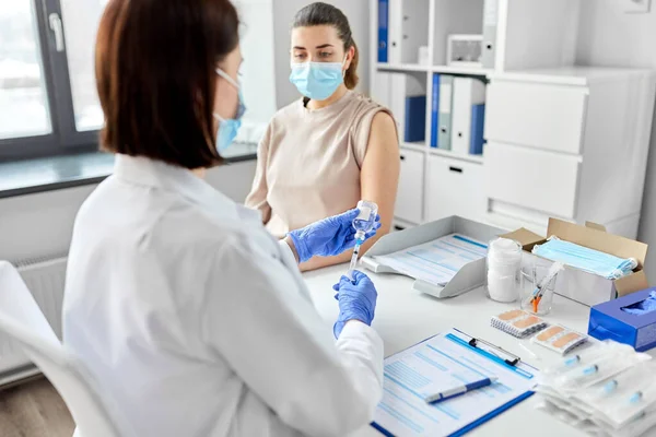 Female doctor with syringe vaccinating patient — Stock Photo, Image