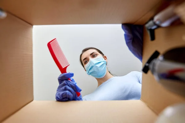 Vrouw in masker uitpakken pakket doos met cosmetica — Stockfoto