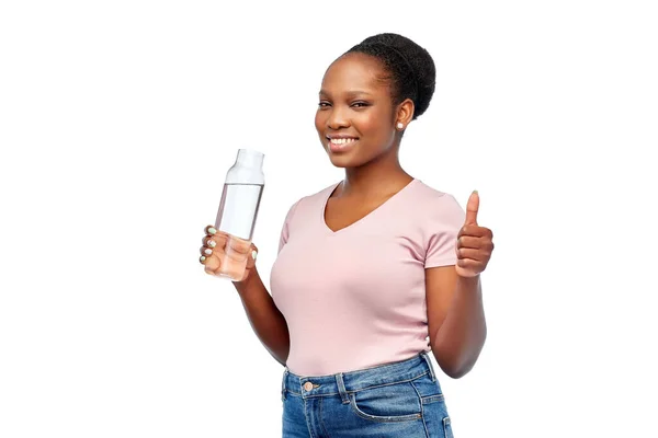 Felice donna africana beve acqua dalla bottiglia di vetro — Foto Stock