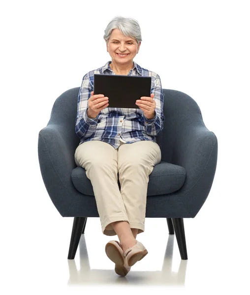 Glückliche Seniorin mit Tablet-PC im Stuhl — Stockfoto