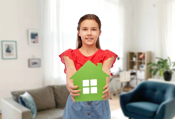 Glimlachend klein meisje met groene huis pictogram — Stockfoto