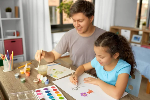 Feliz padre con hija pequeña dibujando en casa —  Fotos de Stock