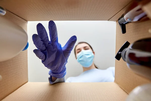 Mulher em máscara desembalagem caixa de pacote com cosméticos — Fotografia de Stock