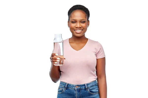 Felice donna africana beve acqua dalla bottiglia di vetro — Foto Stock