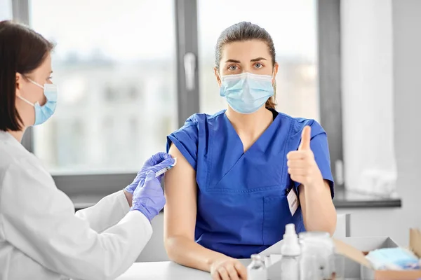 Doctor with syringe vaccinating medical worker — Stock Photo, Image