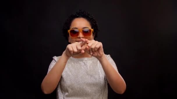 Žena ve slunečních brýlích tančící se zářivými liniemi — Stock video