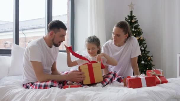 Família feliz com presentes de Natal na cama em casa — Vídeo de Stock