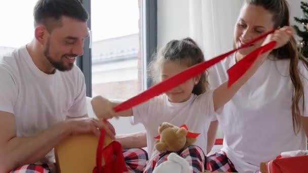 Família feliz com presentes de Natal na cama em casa — Vídeo de Stock