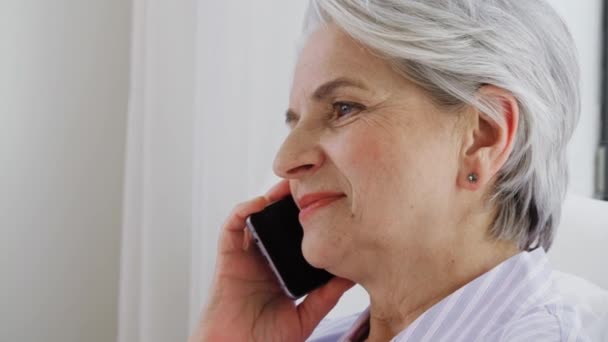 Mulher sênior chamando no smartphone na cama em casa — Vídeo de Stock