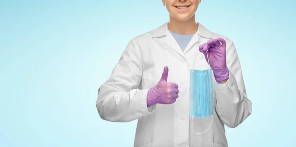Женщина-врач в медицинской маске показывает большие пальцы вверх — стоковое фото