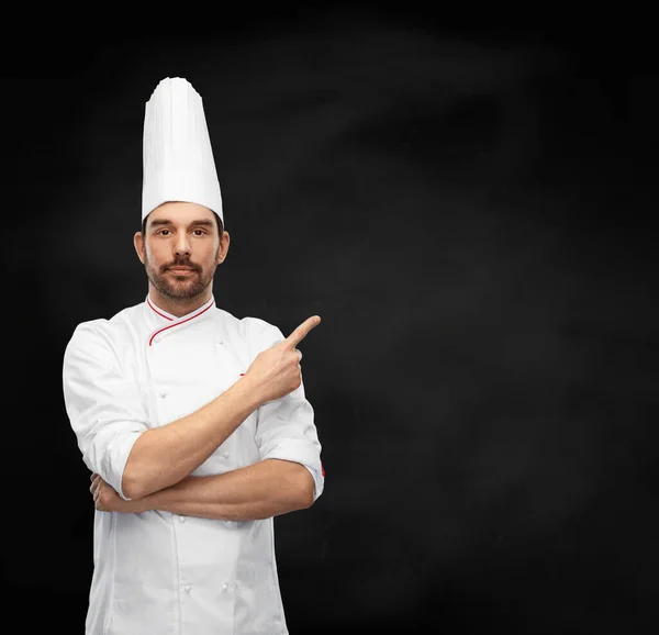 Chef masculino no toque apontando dedo no preto — Fotografia de Stock