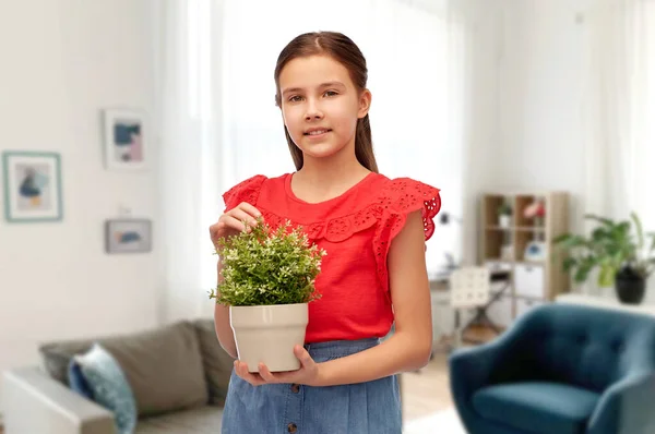 Felice ragazza sorridente che tiene il fiore in vaso a casa — Foto Stock