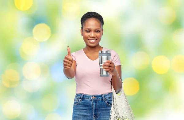 Woman with tumbler and food in string bag — Stock Photo, Image