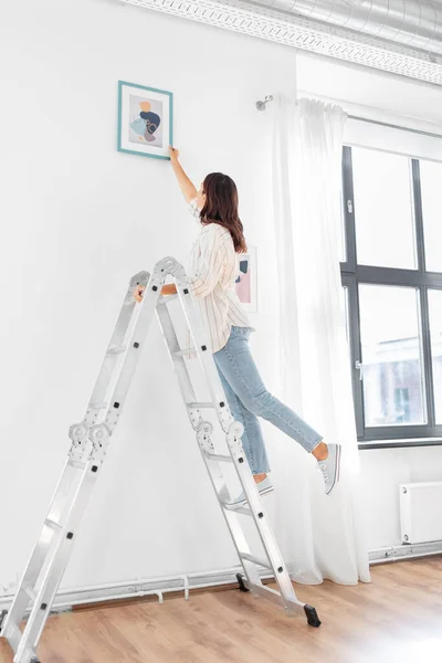 Merdivendeki kadın evi sanatla dekore ediyor. — Stok fotoğraf