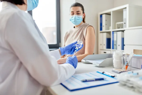 Kvinnlig läkare med spruta vaccinerande patient — Stockfoto