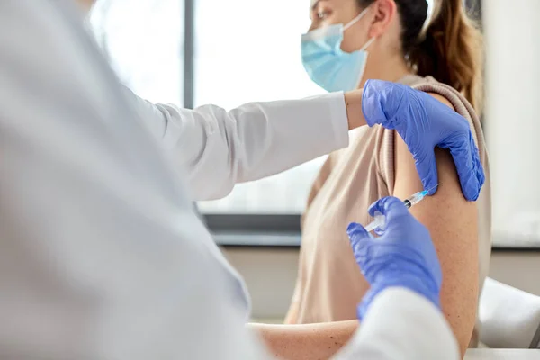 Kvinnlig läkare med spruta vaccinerande patient — Stockfoto