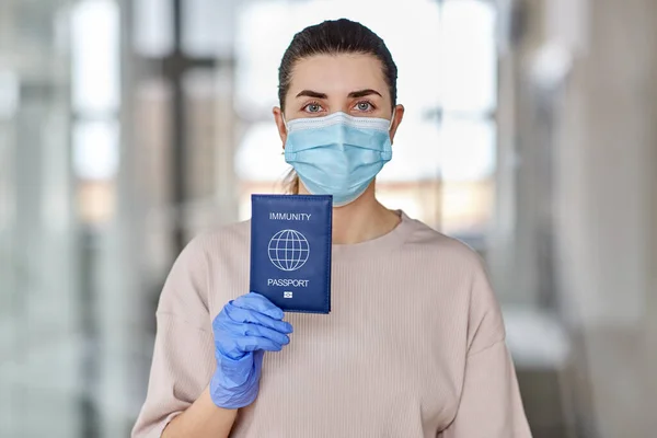 Mujer con máscara y guantes con pasaporte de inmunidad — Foto de Stock