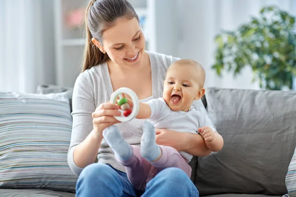 Madre y pequeño bebé jugando con sonajero en casa —  Fotos de Stock