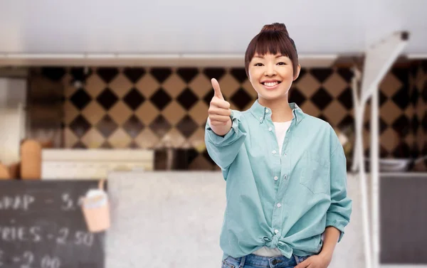 Asian woman showing thumbs up over food truck — Stock Photo, Image