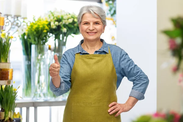 Mujer mayor en delantal de jardín mostrando los pulgares hacia arriba — Foto de Stock