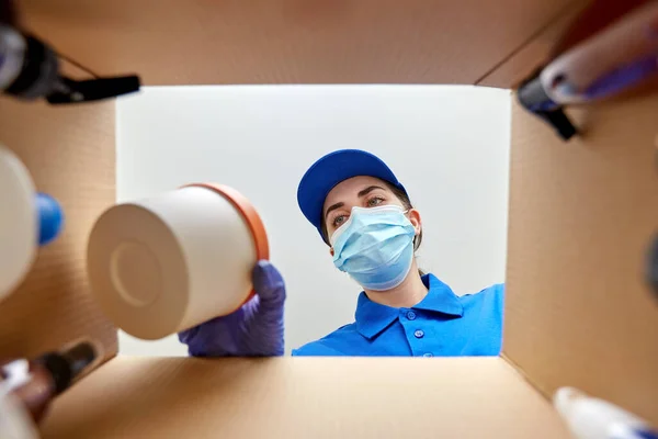 Kvinna i mask förpackning paket låda med kosmetika — Stockfoto