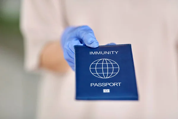 Mulher de luva segurando passaporte imunidade — Fotografia de Stock