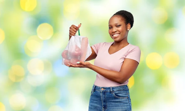Mujer feliz con verduras en bolsa de red reutilizable — Foto de Stock