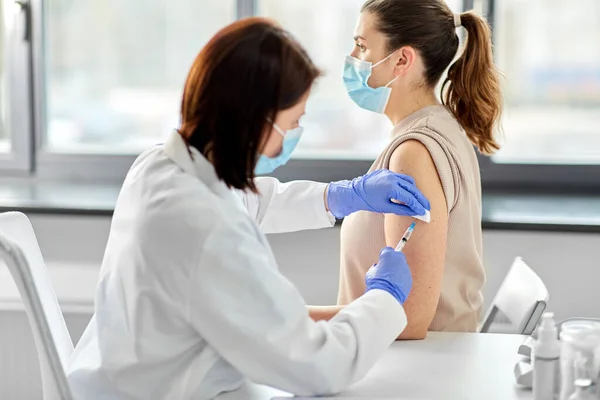 Kvinnlig läkare med spruta vaccinerande patient — Stockfoto