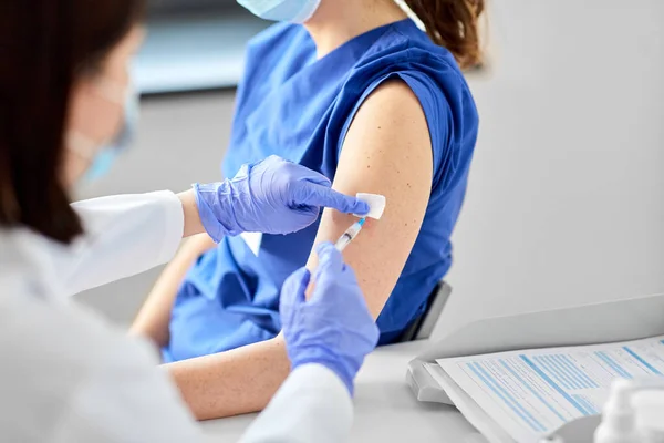 Médico con jeringa vacunando al trabajador médico — Foto de Stock