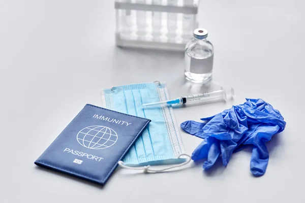 Pasaporte de inmunidad, máscara, jeringa, vacuna sobre la mesa — Foto de Stock