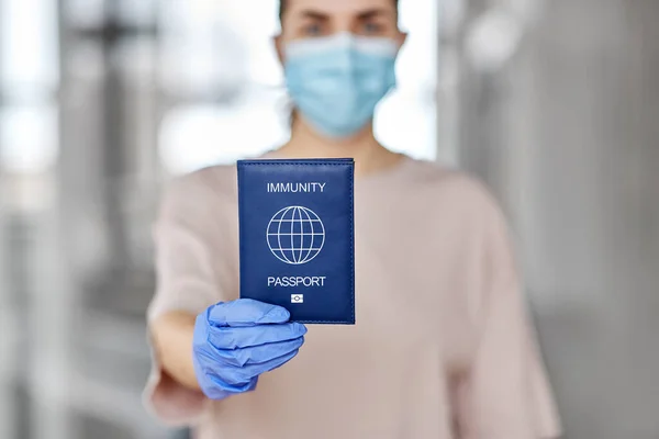 Woman in mask and gloves holding immunity passport — Stock Photo, Image