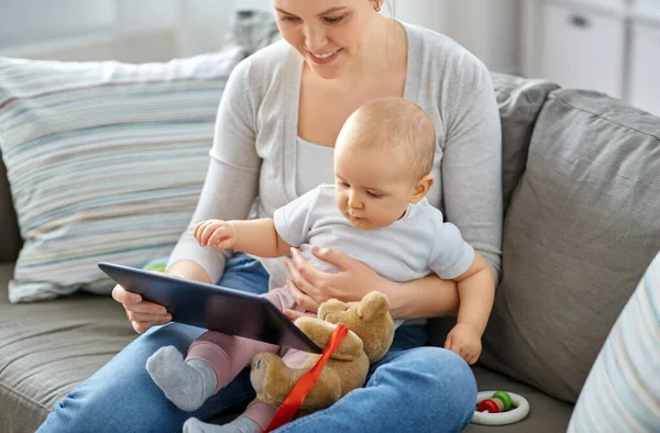 Счастливая мать и девочка с планшетным компьютером дома — стоковое фото