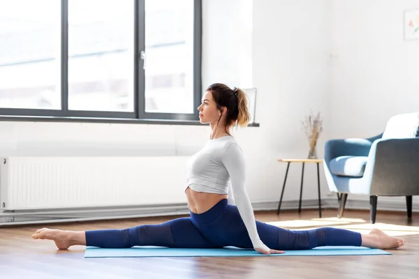 Joven mujer haciendo splits yoga pose en estudio — Foto de Stock