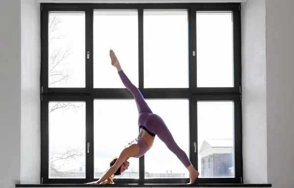 在演播室窗台上做瑜伽练习的女人 — 图库照片
