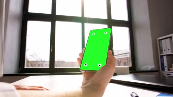 自宅のオフィスで携帯電話の緑の画面で手 — ストック動画