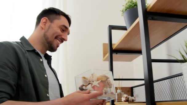 Man decorating home with seashells in vase — Stock Video