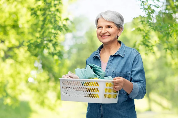 Sonriente mujer mayor con cesta de lavandería — Foto de Stock