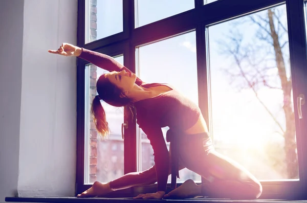 在演播室窗台上做瑜伽练习的女人 — 图库照片