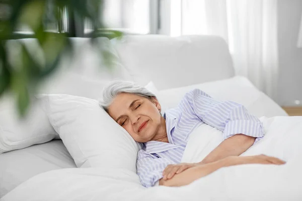 Mulher sênior dormindo na cama em casa quarto — Fotografia de Stock