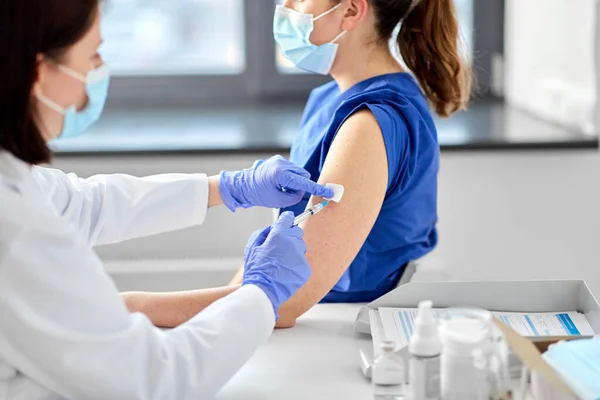 Médico con jeringa vacunando al trabajador médico —  Fotos de Stock