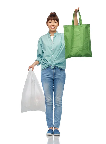 플라스틱을 가지고 있고 재사용 가능 한 쇼핑백을 한 여자 — 스톡 사진