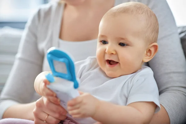 Mãe com bebê brincando com telefone de brinquedo em casa — Fotografia de Stock